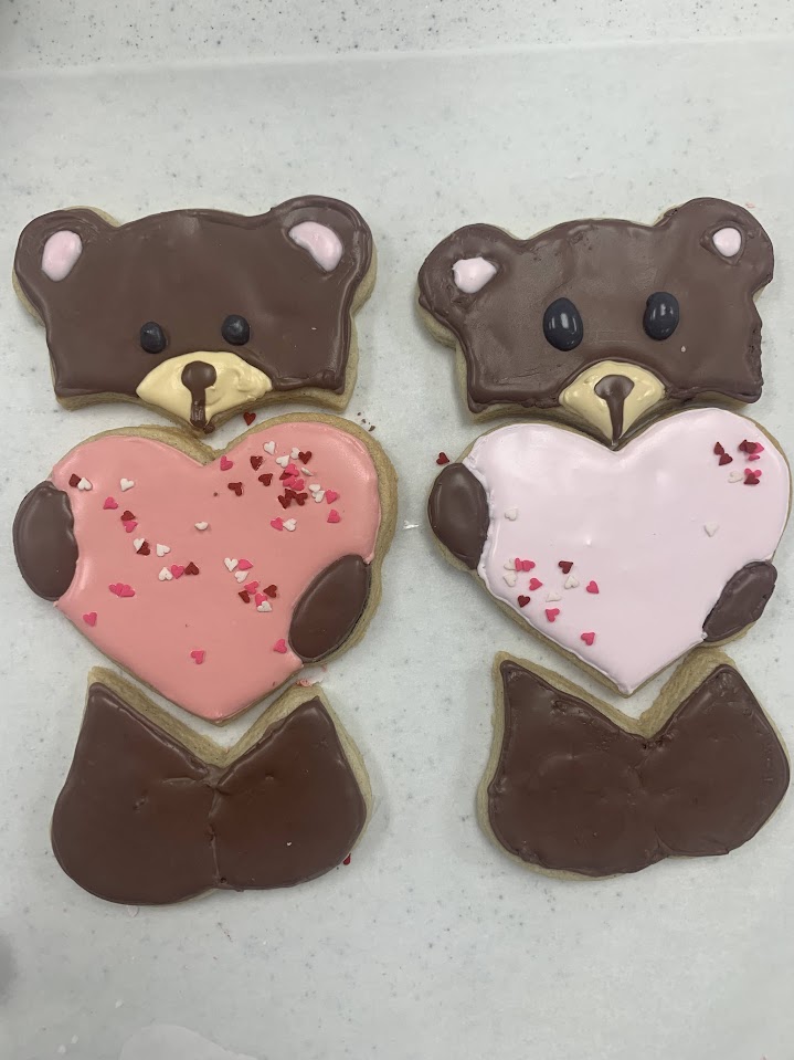 A picture of custom sugar cookies in the shape of a bear holding a heart